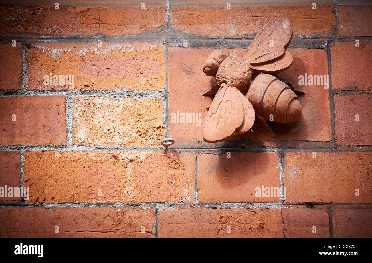 Stone mason Manchester bee details on wall Stock Photo