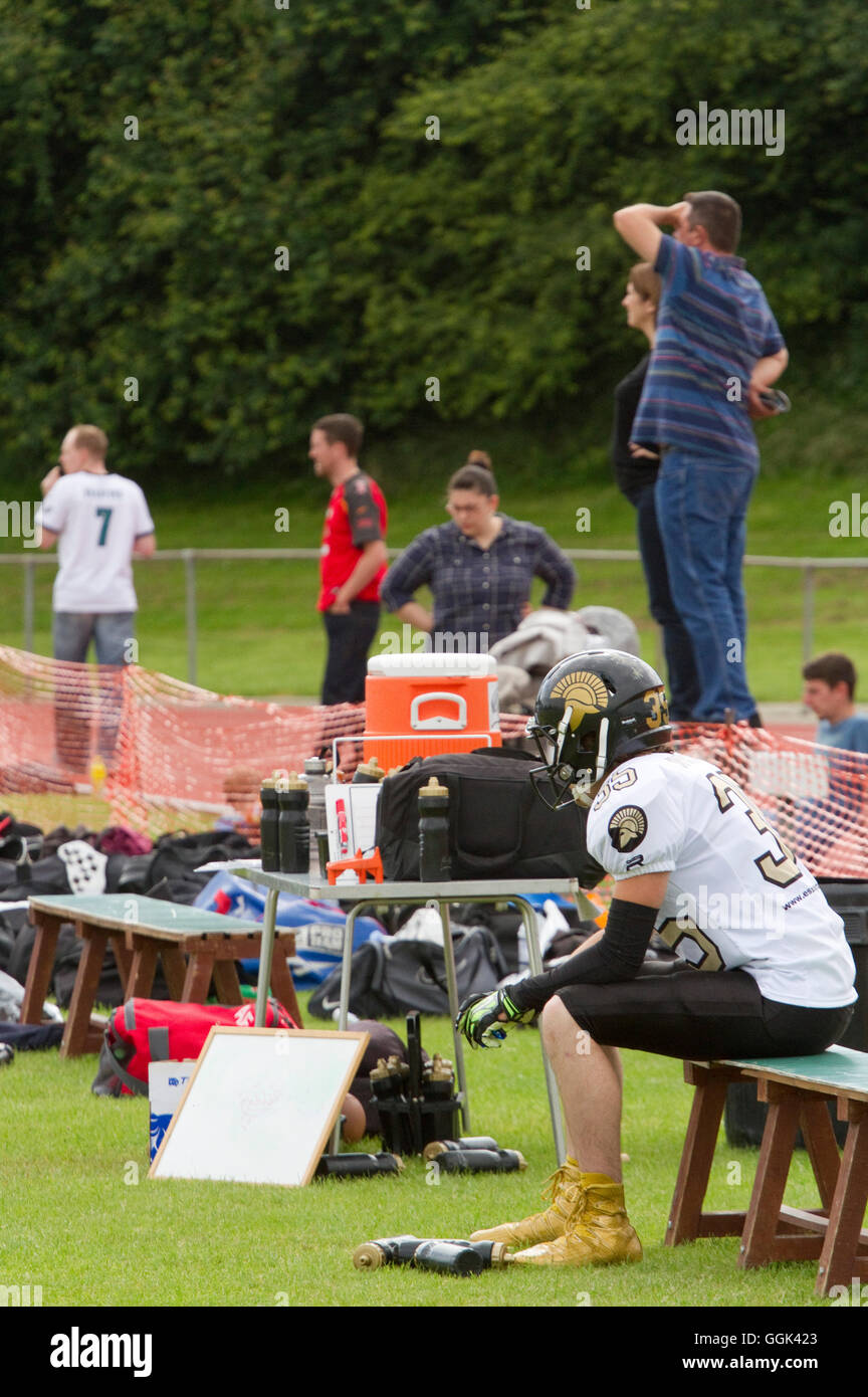 British American football sitting on a sideline spectators in the background Stock Photo