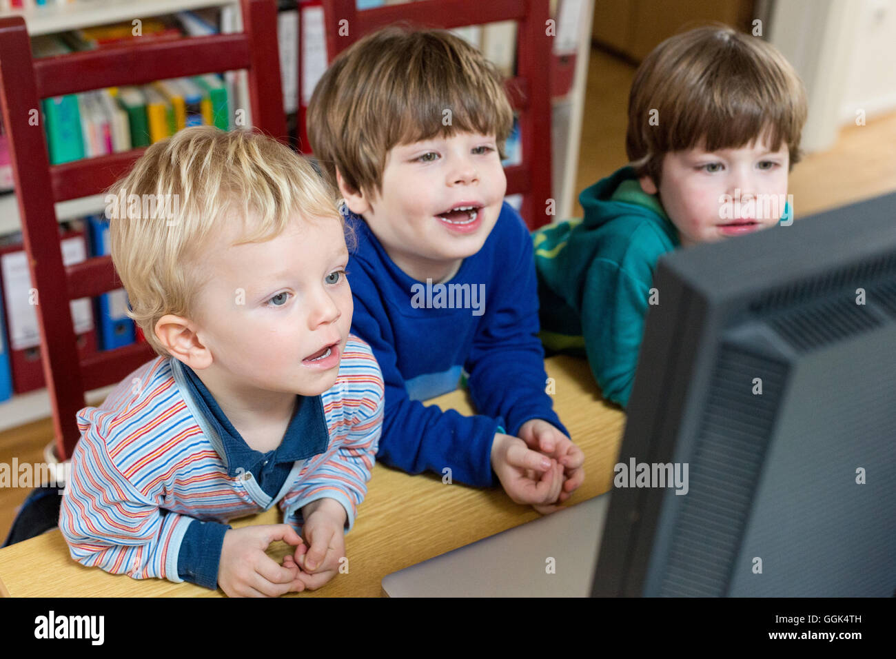 Three boys looking at a computer screen Stock Photo