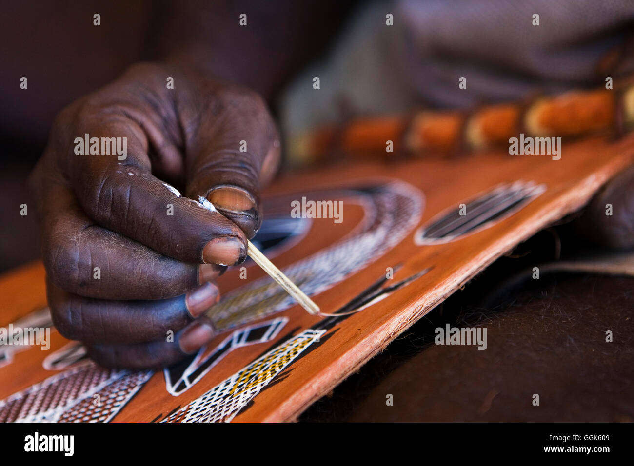 Close-up of hand of an Aborigine painting a fish with old-fashioned brush, Arnhem Land, Northern Territory, Australia Stock Photo