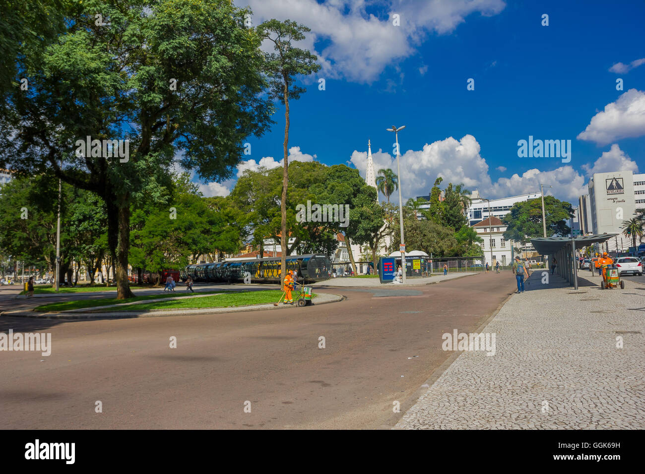 CURITIBA ,BRAZIL - MAY 12, 2016: pedestrians walking arround the bus station surrounded by big trees Stock Photo