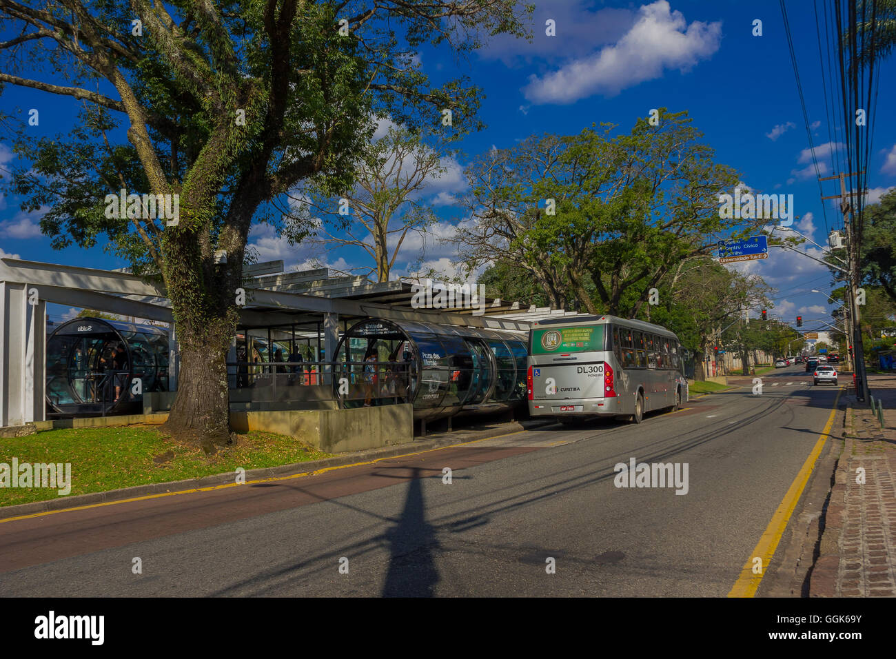 CURITIBA ,BRAZIL - MAY 12, 2016: public gray bus picking up passengers from a station, white car waiting for the green light at the corner Stock Photo