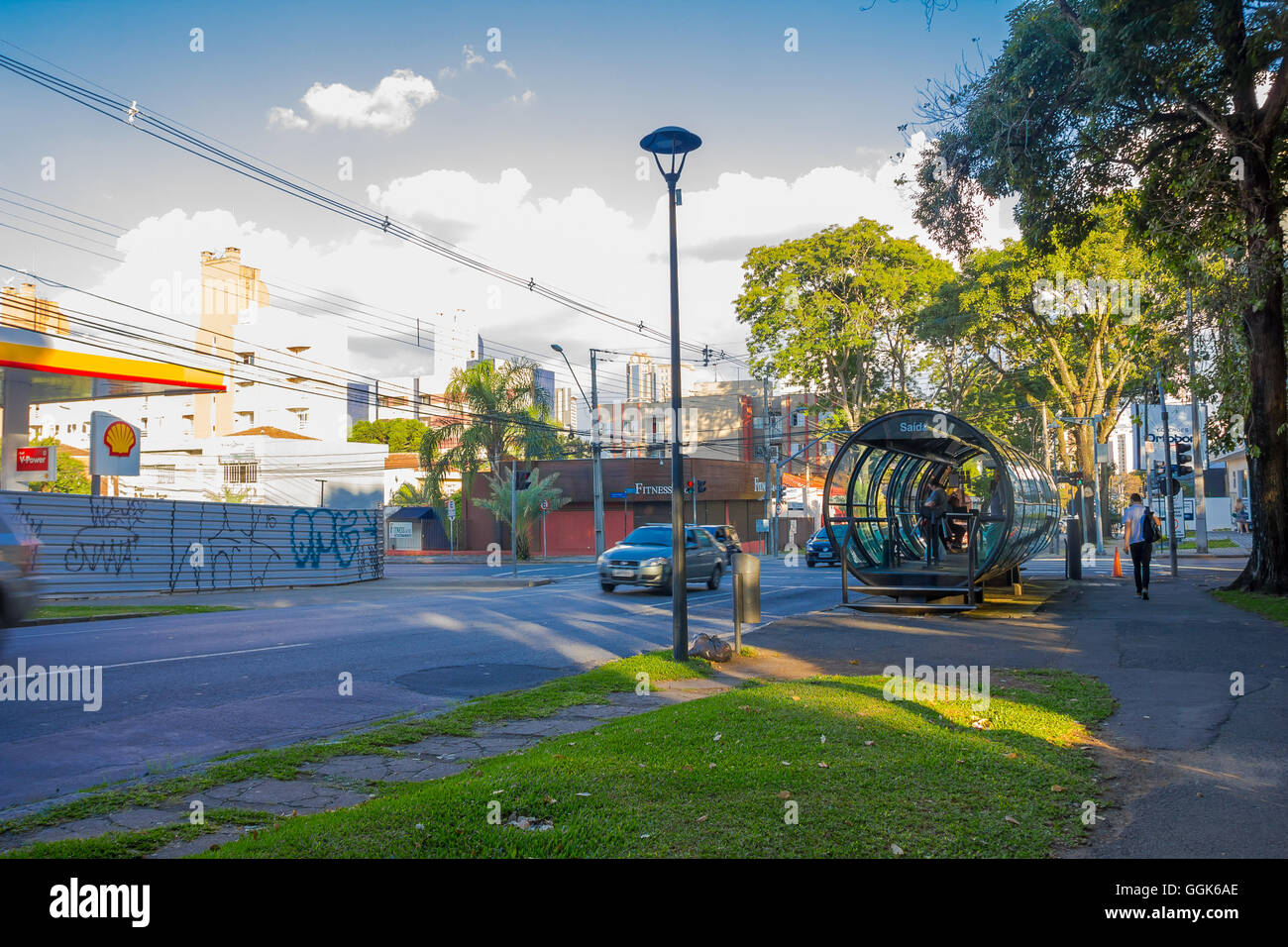 CURITIBA ,BRAZIL - MAY 12, 2016: passengers waiting for the bus on the station while some cars are driving in the street Stock Photo