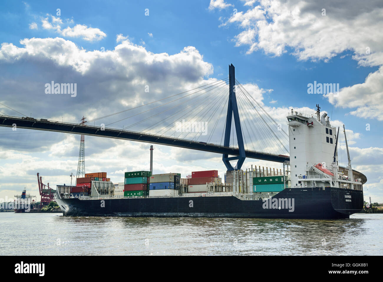 Container ship sailing on the river Elbe beneath the Koehlbrandbruecke bridge, river Elbe, Hamburg, Germany Stock Photo