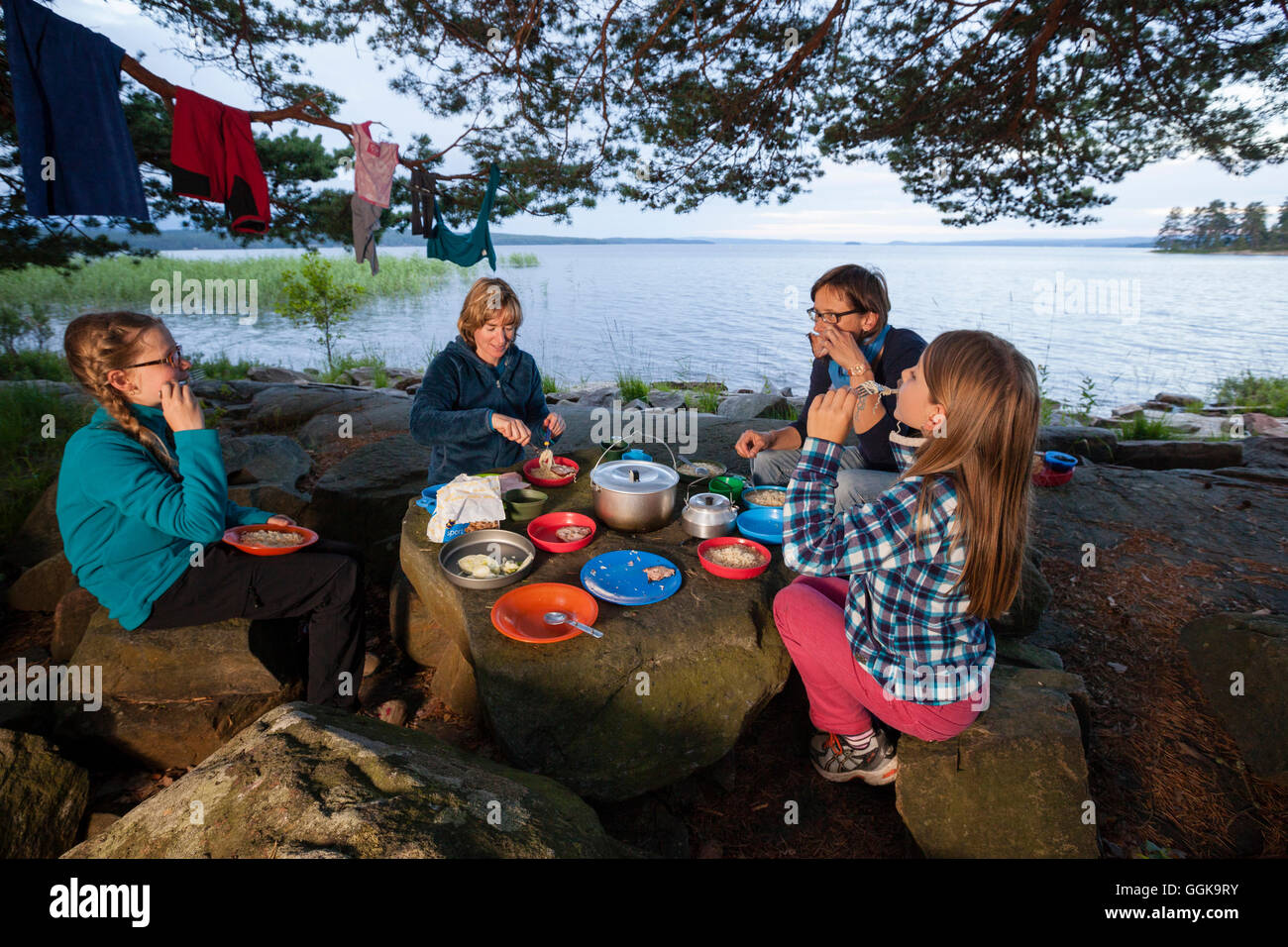 Two girls and two women having dinner at the lake Glafsfjorden, Vaermland, Schweden Stock Photo