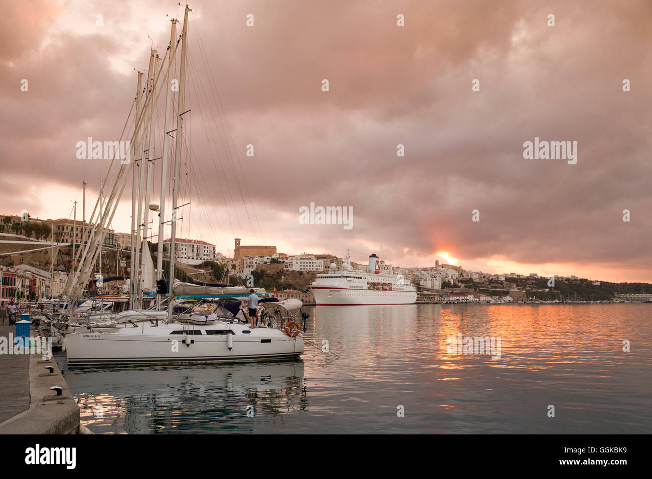Sailing boats in the marina and cruise ship MS Deutschland (Reederei Peter Deilmann) at pier at sunset, Mahon, Menorca, Balearic Stock Photo