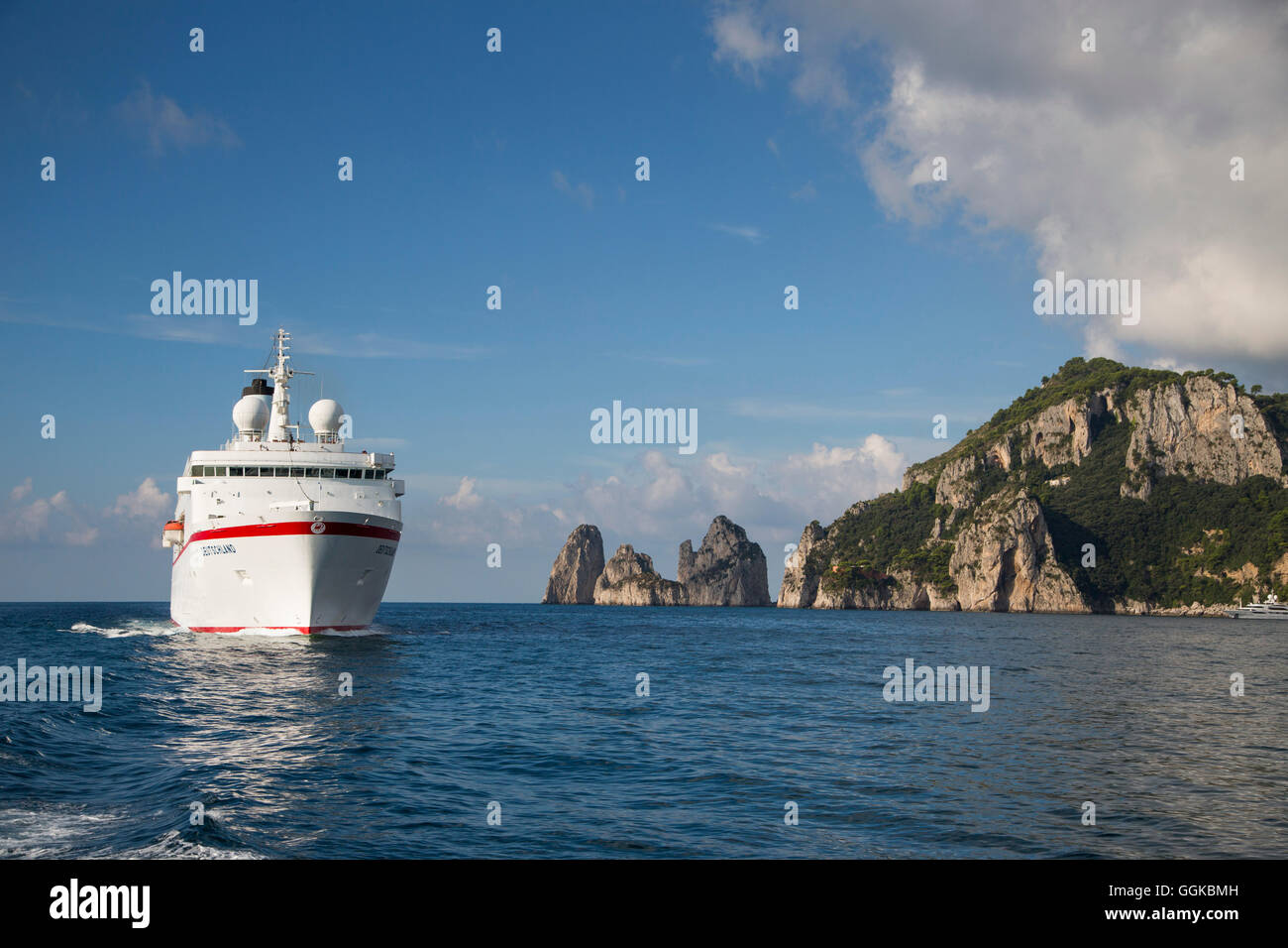 Cruise ship MS Deutschland (Reederei Peter Deilmann) passing Faraglioni Rocks and coastline, Isola di Capri, Campania, Italy Stock Photo