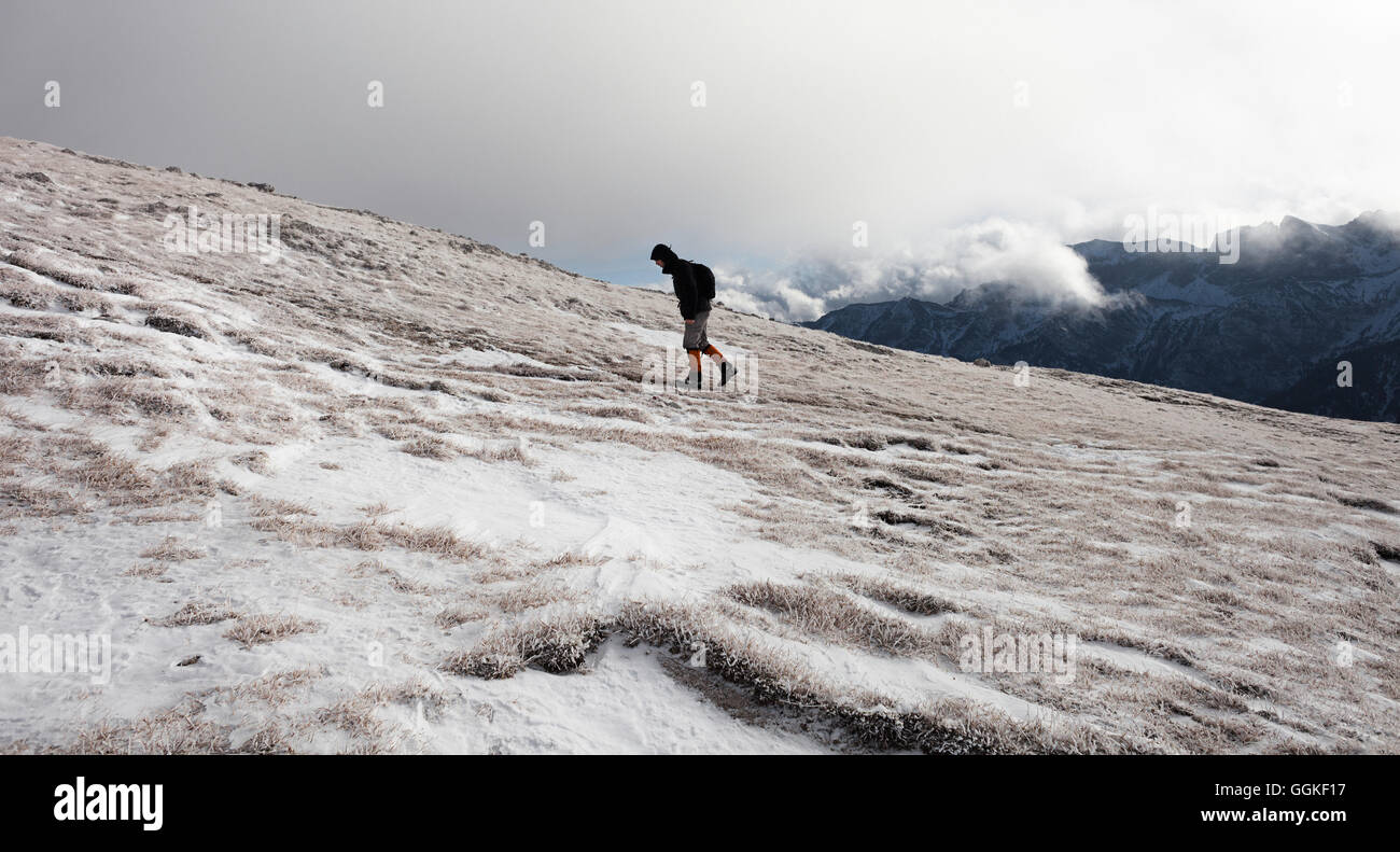 Hiker walking in snow-covered landscape, ascend to Unnutz Mountain (2078 m), Rofan Mountains, Tyrol, Austria Stock Photo
