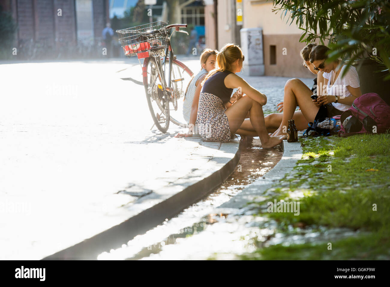 Teenage girls cooling their feet in a stream, Freiburg im Breisgau, Black Forest, Baden-Wuerttemberg, Germany Stock Photo