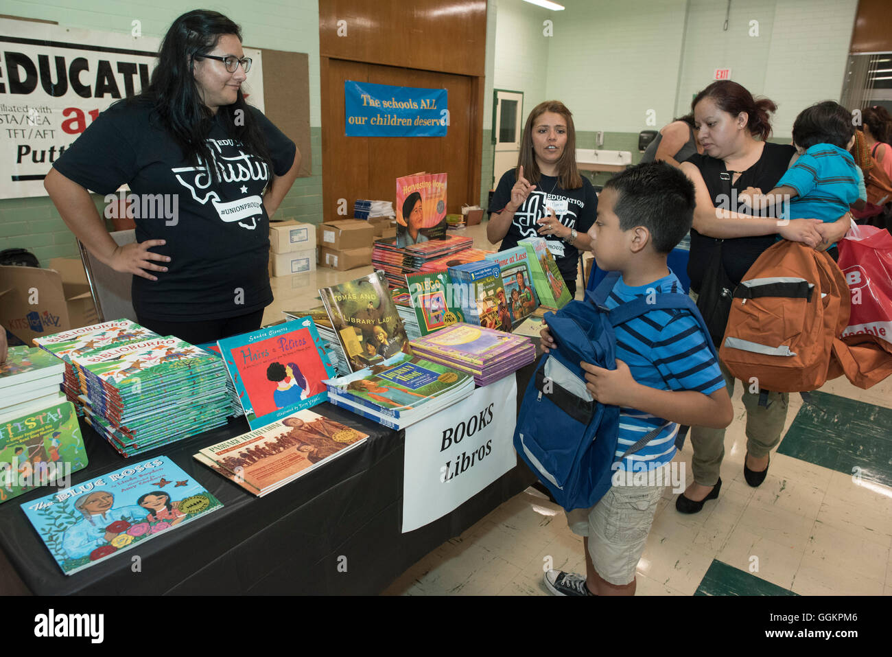 Kids and parents look through free school supplies and books at summer