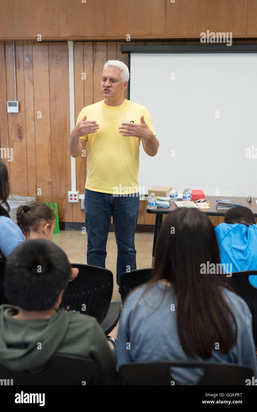 Male instructor teaches parents tips on how to help their kids succeed in school at workshop for English language learners Stock Photo