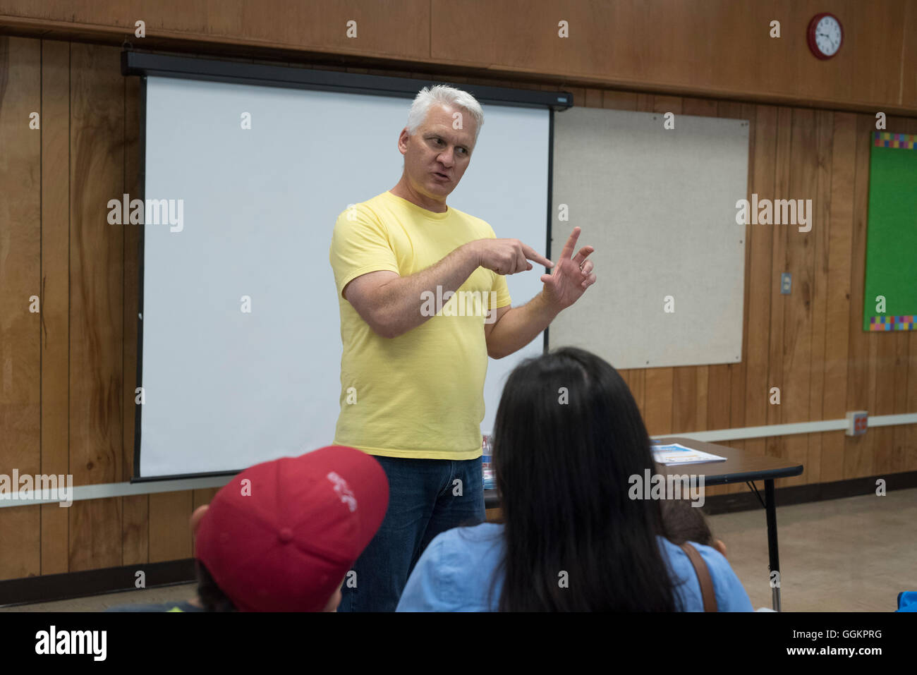Male instructor teaches parents tips on how to help their kids succeed in school at workshop for English language learners Stock Photo