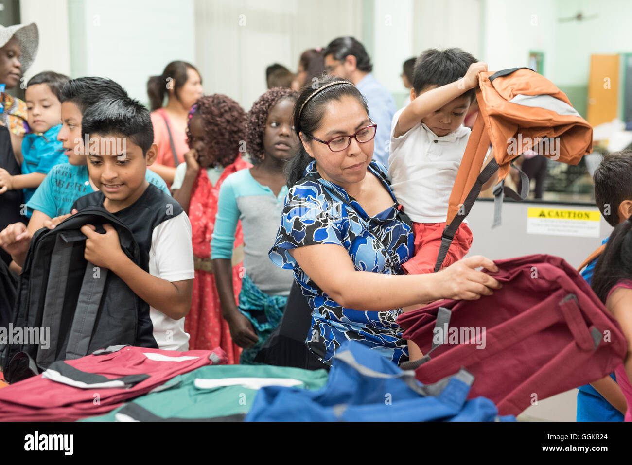 Kids and parents look through free school supplies at summer program