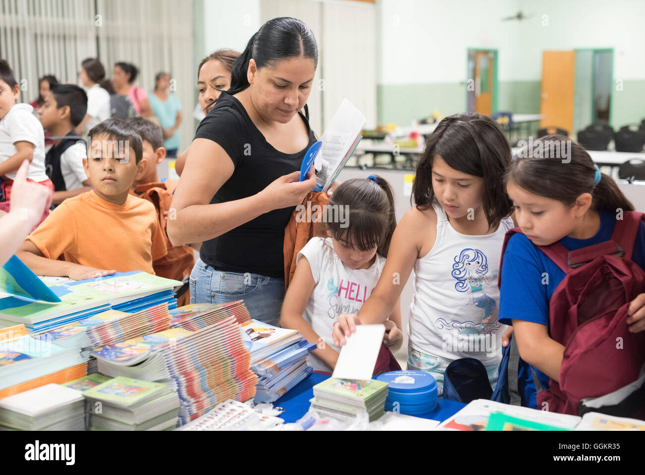 Kids and parent look through free school supplies learning aides at