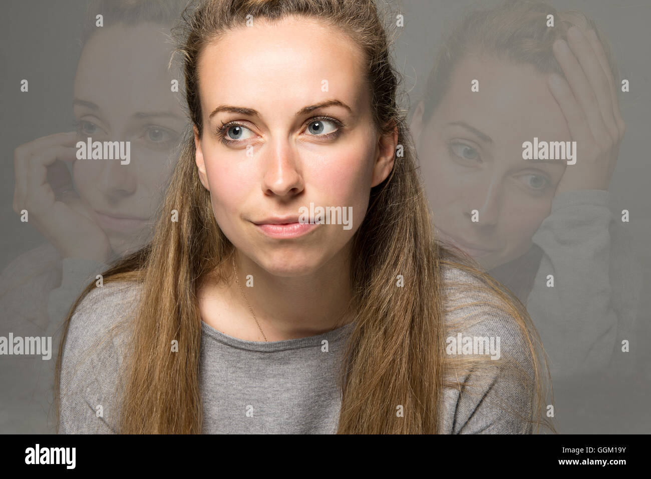 Sad concept young woman with wry smile but hiding tears and sadness in images behind Stock Photo