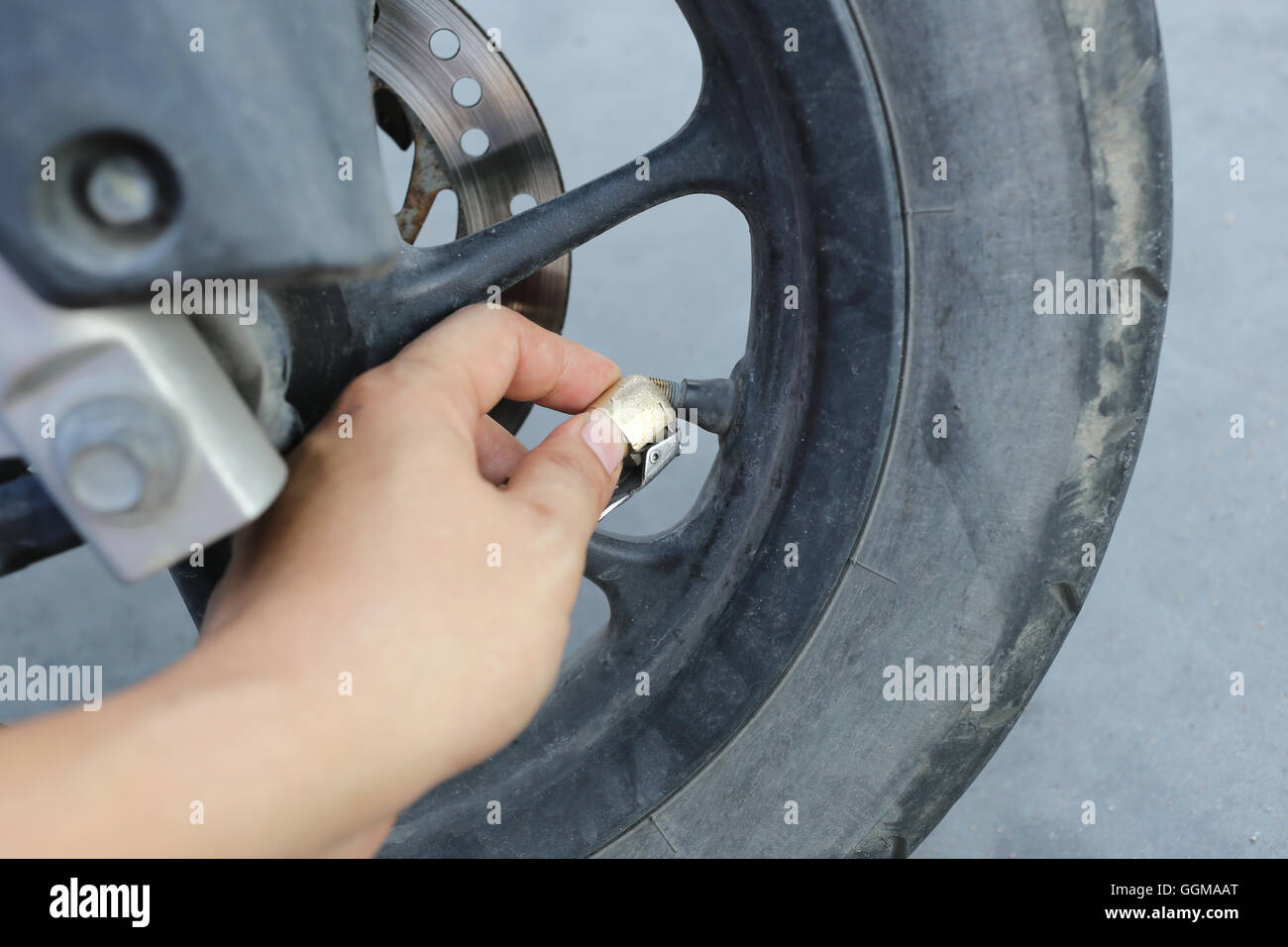 Hand of man fill a wind into the wheels of motorcycle this maintenance before leaving traveling. Stock Photo