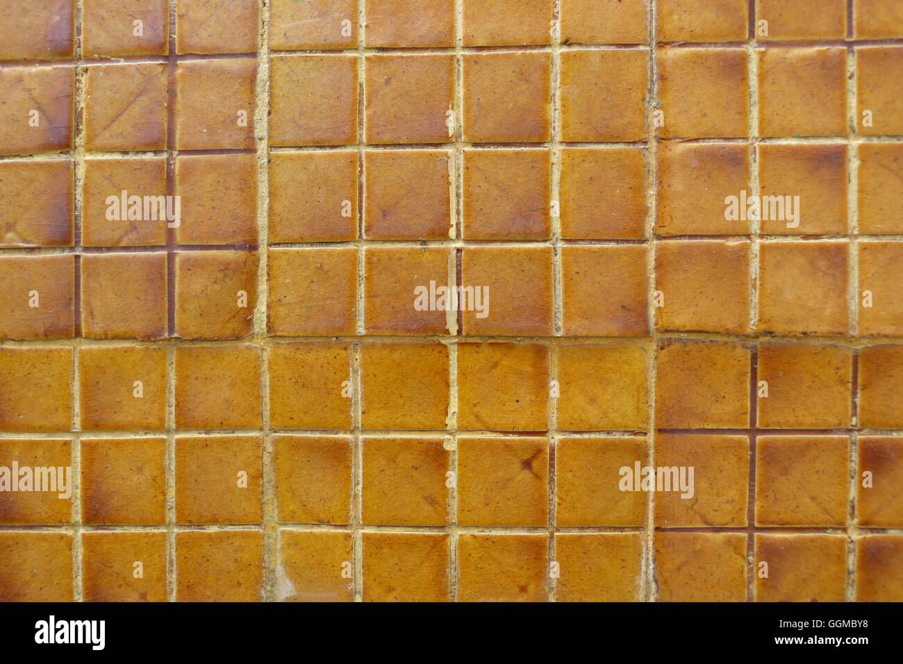 Old orange grunge wall tiles of the building texture for the design background. Stock Photo