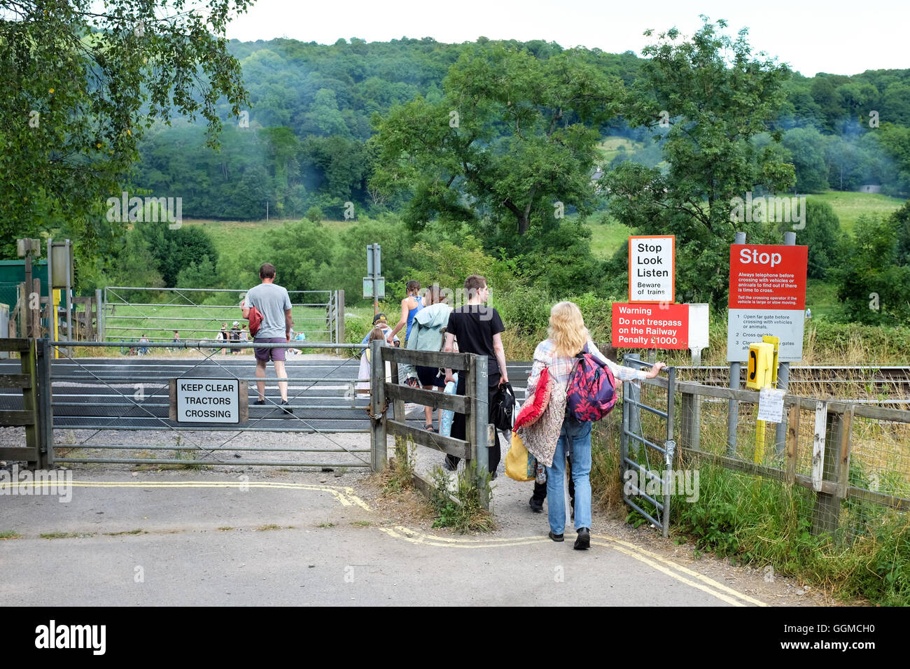 People crossing an unmanned, non-auto train crossing near Bath, England. There are no lights here to warn of approaching trains. Stock Photo