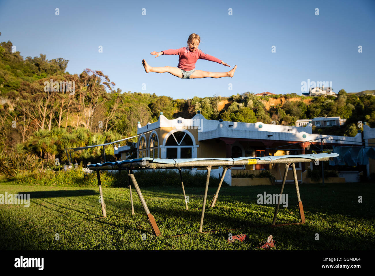 A girl jumping on the trampoline at the Sans Souci Inn, Pohara, Golden Bay, South Island, New Zealand Stock Photo