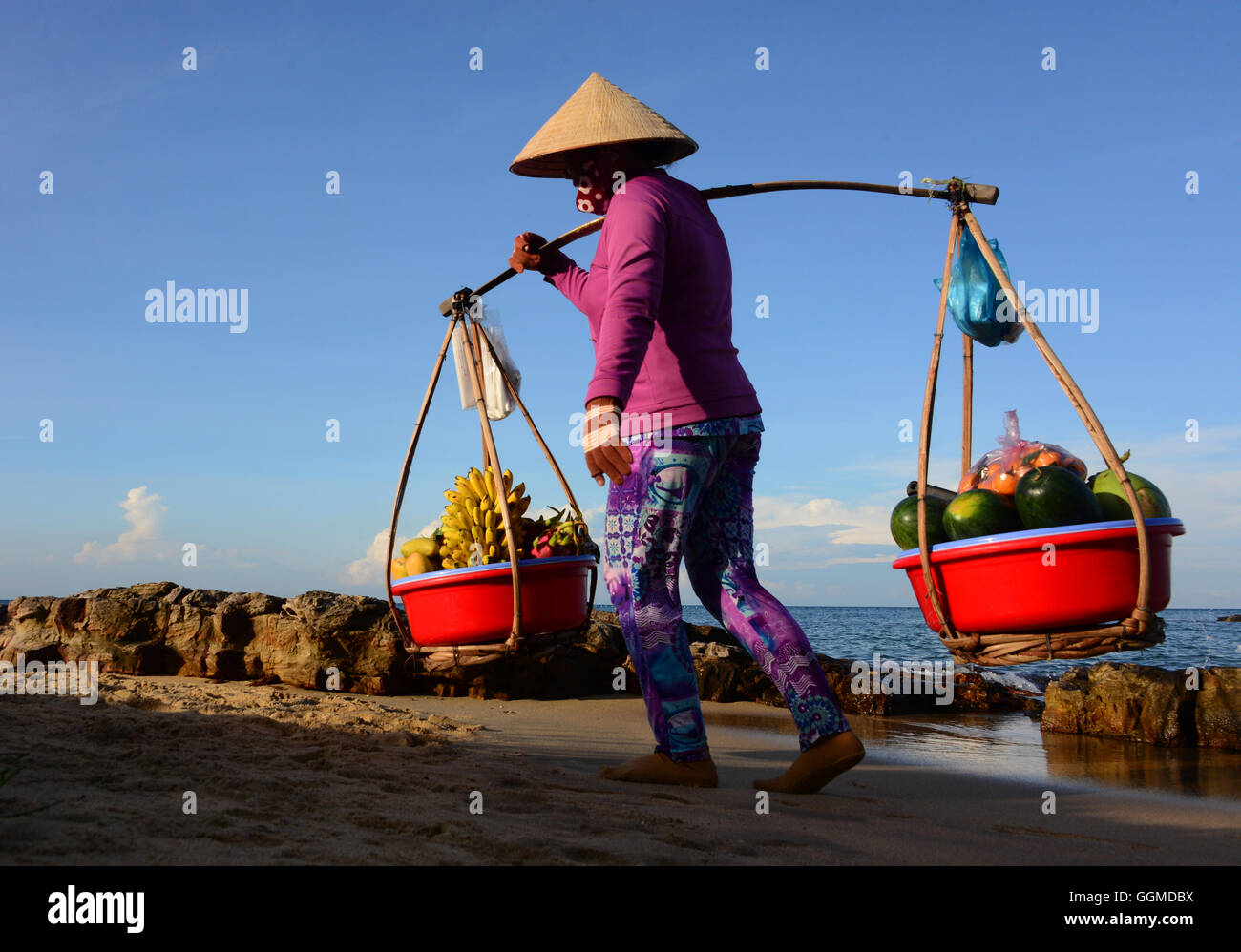 Woman carrying friut, Longbeach on the island of Phu Quoc, Vietnam, Asia Stock Photo