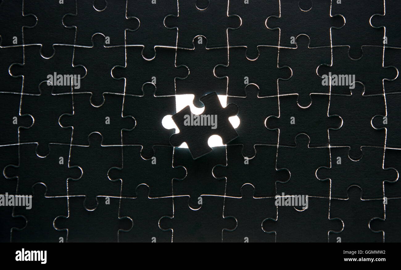 Assembled black puzzle with one wrong-placed element Stock Photo