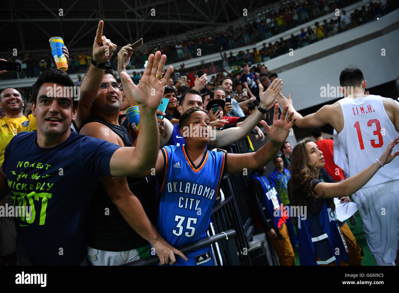 Fans cheer in the stands next to Muhao Li (R) of China after the Basketball Men's Preliminary Round Group A match of the Rio 2016 Olympic Games at the Carioca Arena 1, Rio de Janeiro, Brazil, 6 August 2016. Photo: Lukas Schulze/dpa Stock Photo