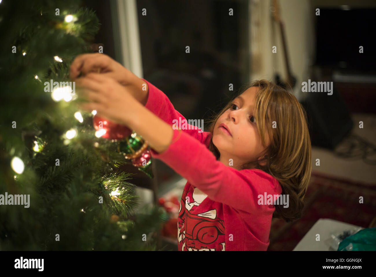 Caucasian boy hanging ornament on Christmas tree Stock Photo