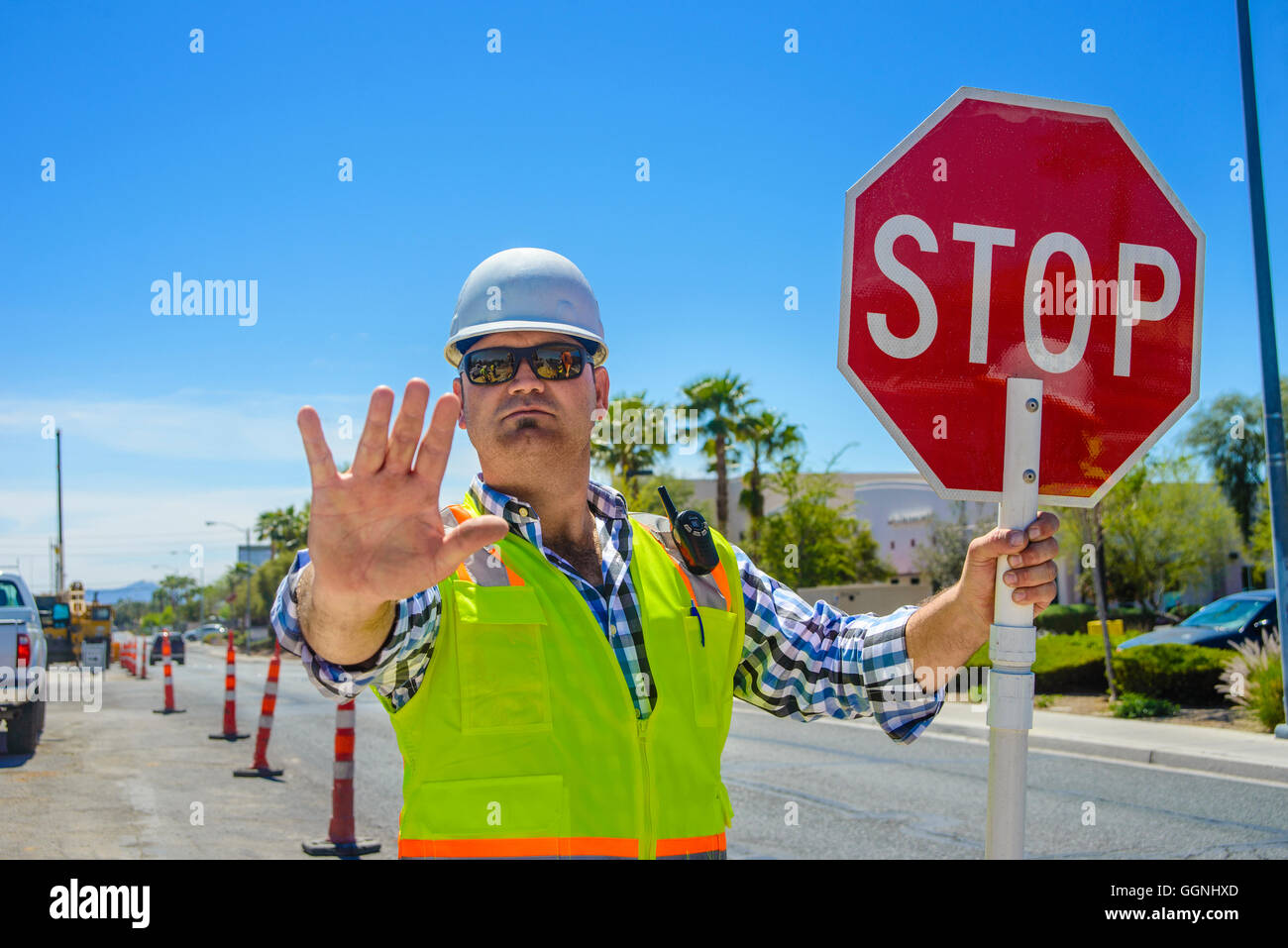 Caucasian flagger gesturing stop with stop sign Stock Photo