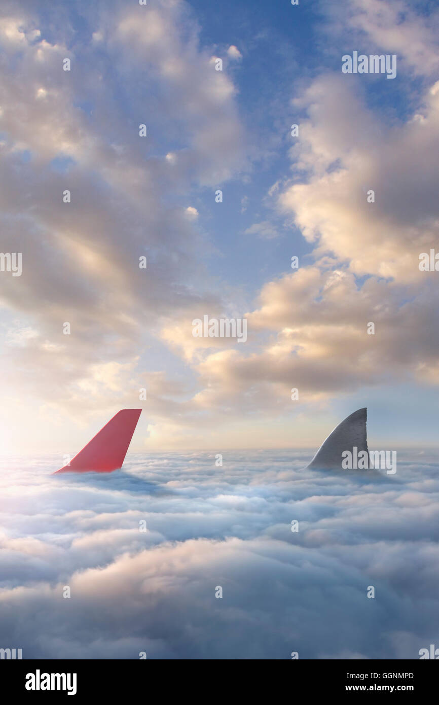Shark fin chasing airplane rudder above clouds Stock Photo