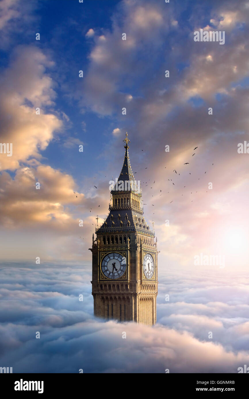 Birds flying around clock tower above clouds Stock Photo