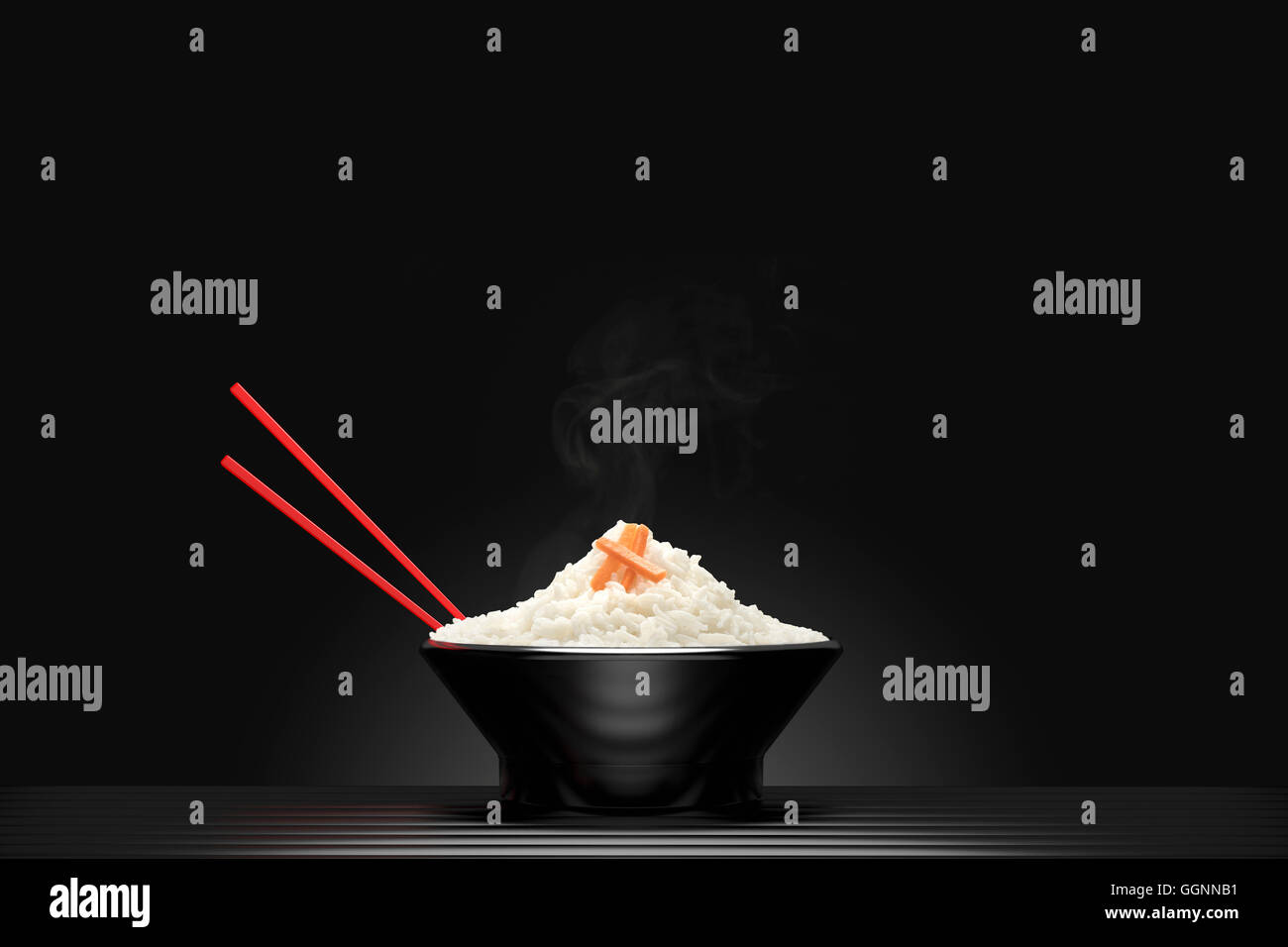 Chopsticks in bowl of steaming white rice Stock Photo