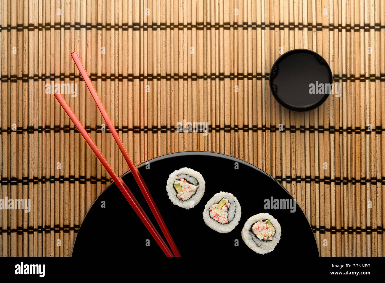 Chopsticks and sushi on round plate with dipping sauce Stock Photo