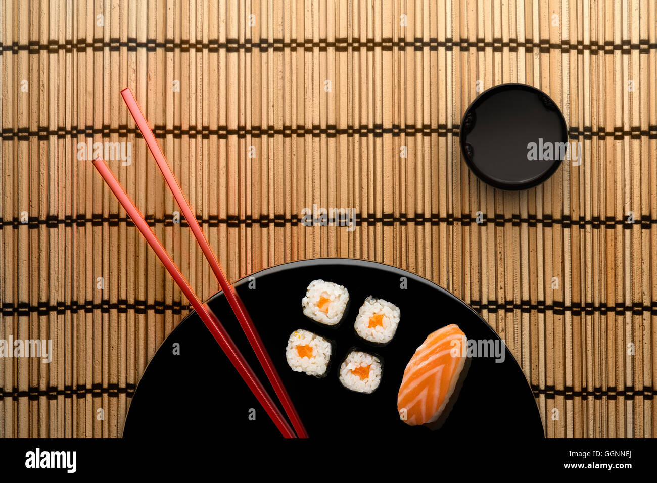 Chopsticks and sushi on round plate with dipping sauce Stock Photo