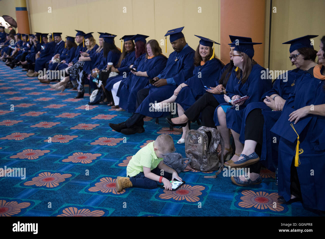 Graduation candidates in caps and gowns wait for Western Governors