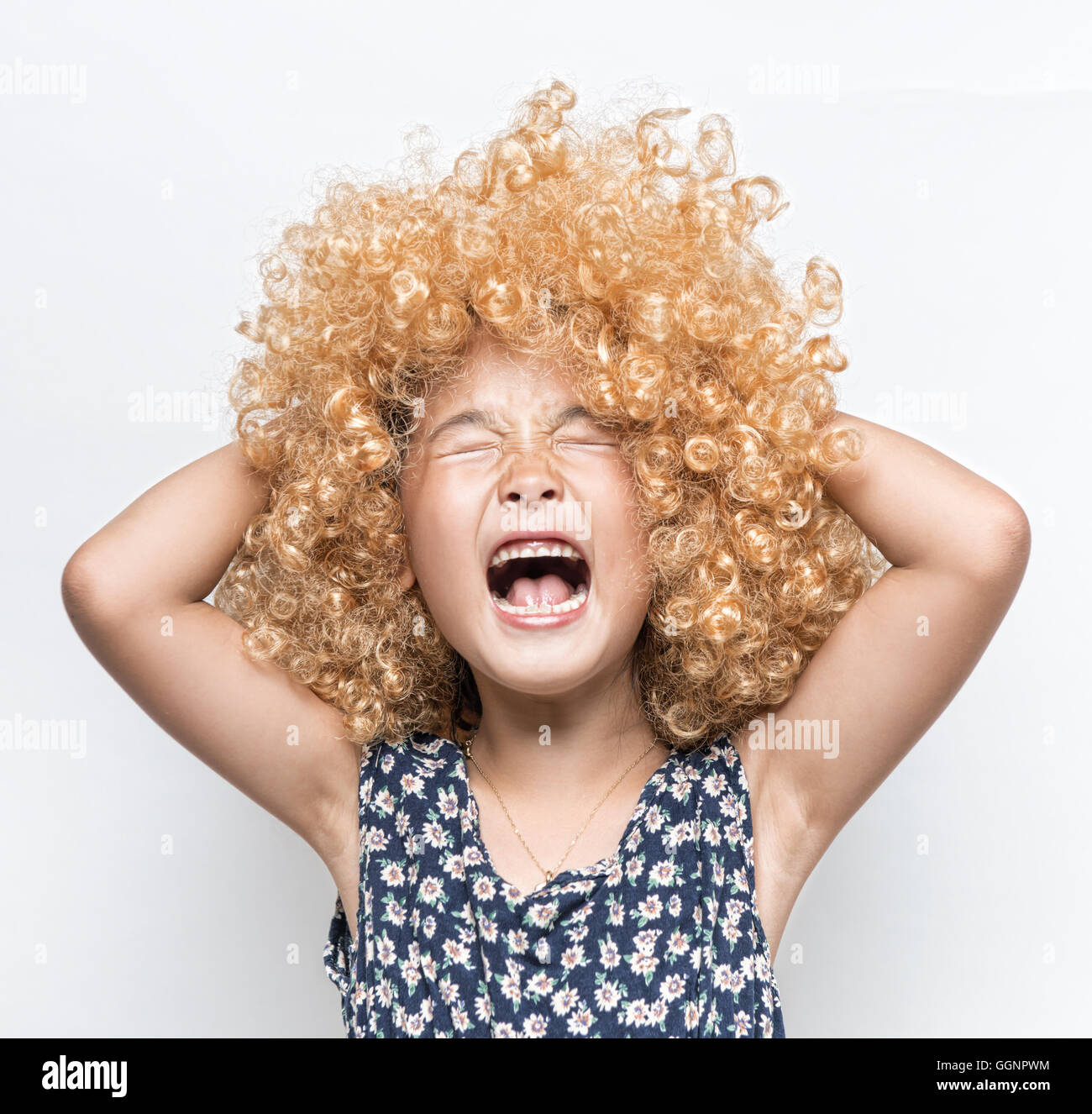 Wearing a blonde wig and funny facial expression Asian girl Stock Photo