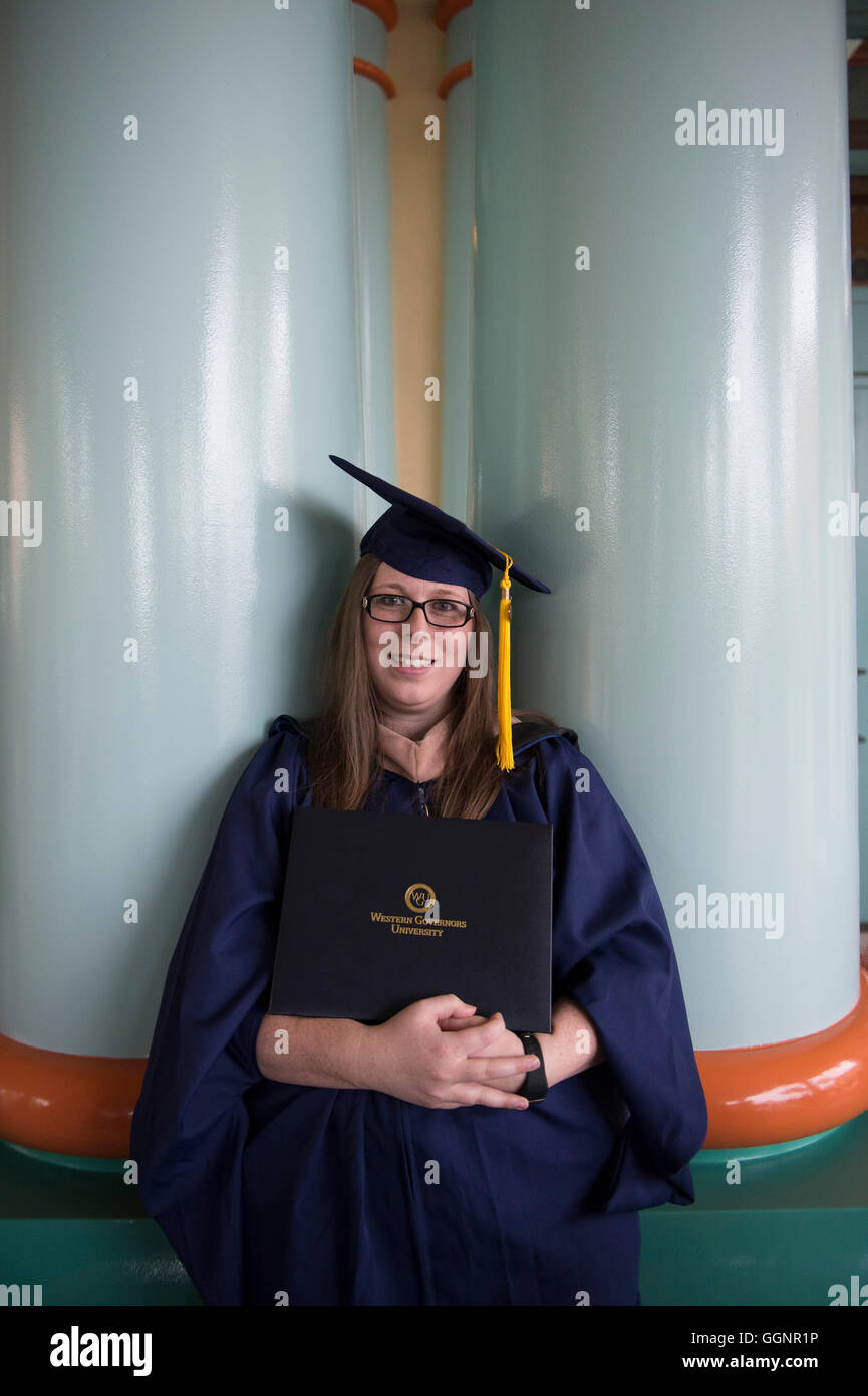 Graduate of Western Governors University poses with diploma after