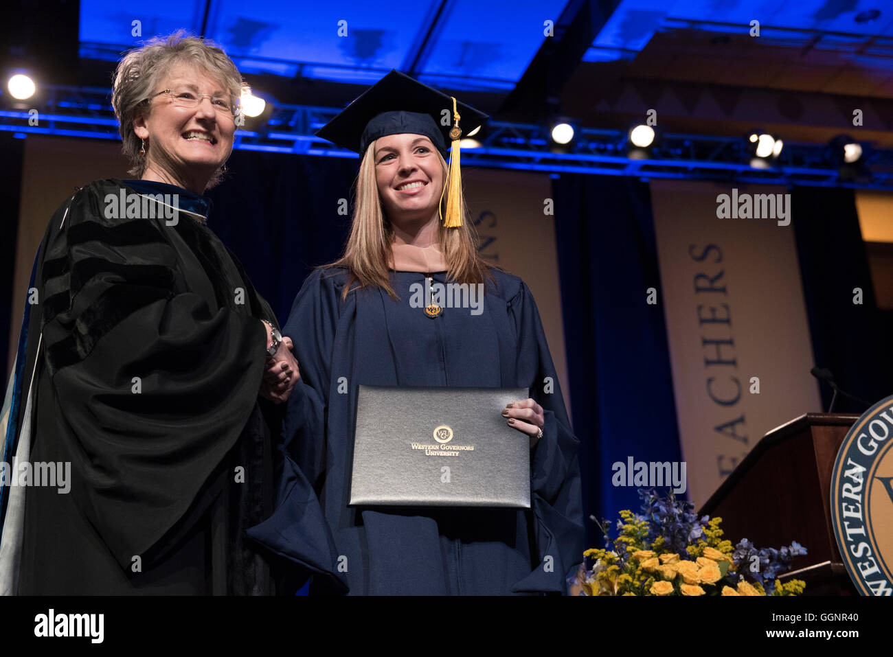 Student pose with diploma during commencement ceremony for Western