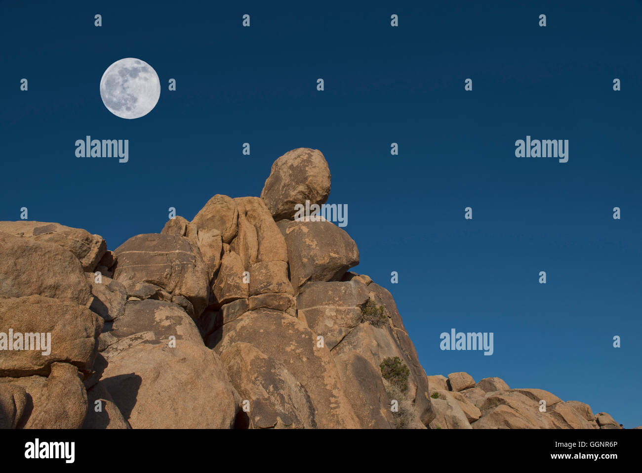 Full moon above rock formation, Mojave Desert, California, United States, Stock Photo