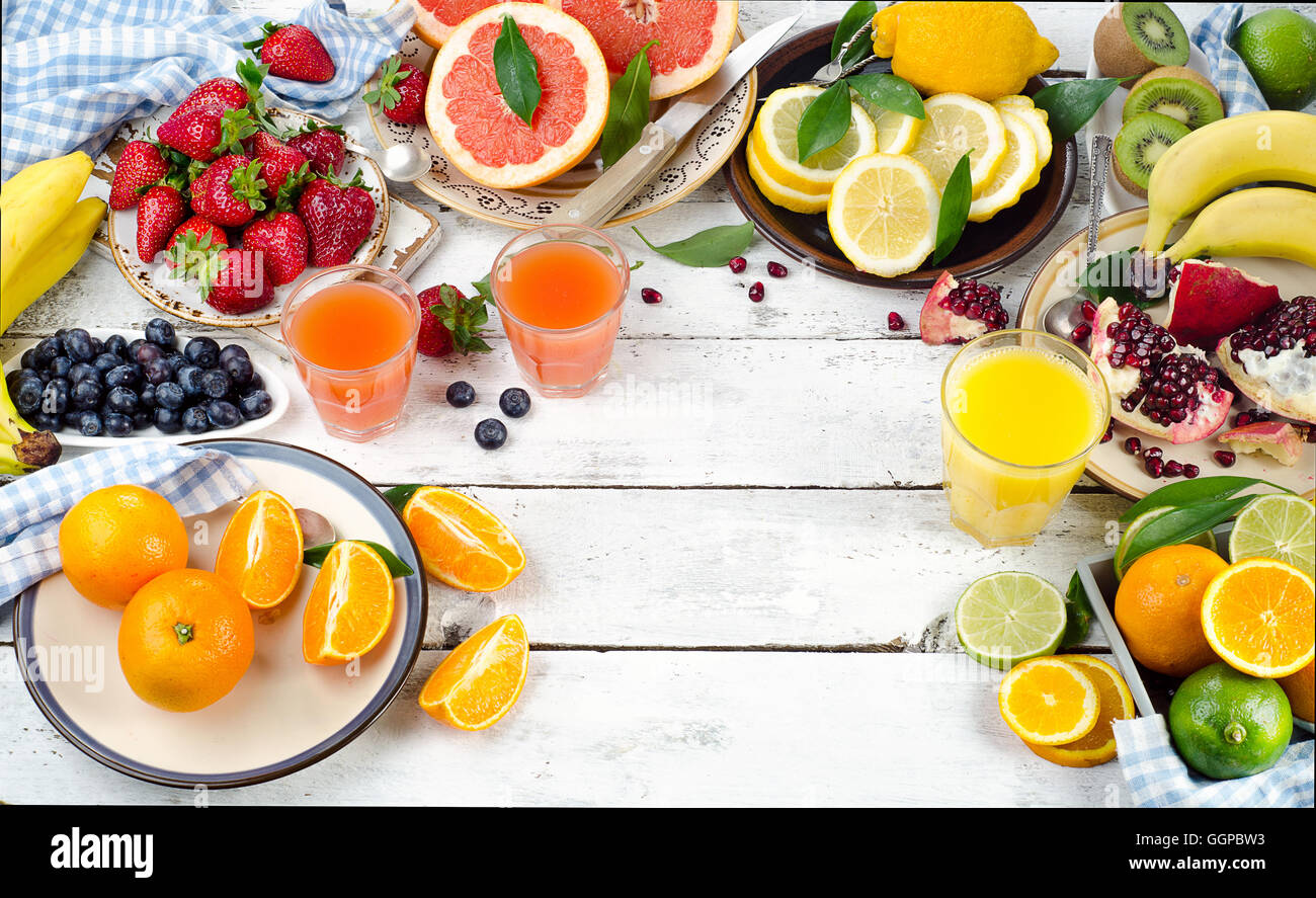 Citrus juice, fruits and berries on white wooden background. Healthy eating, dieting. Top view Stock Photo