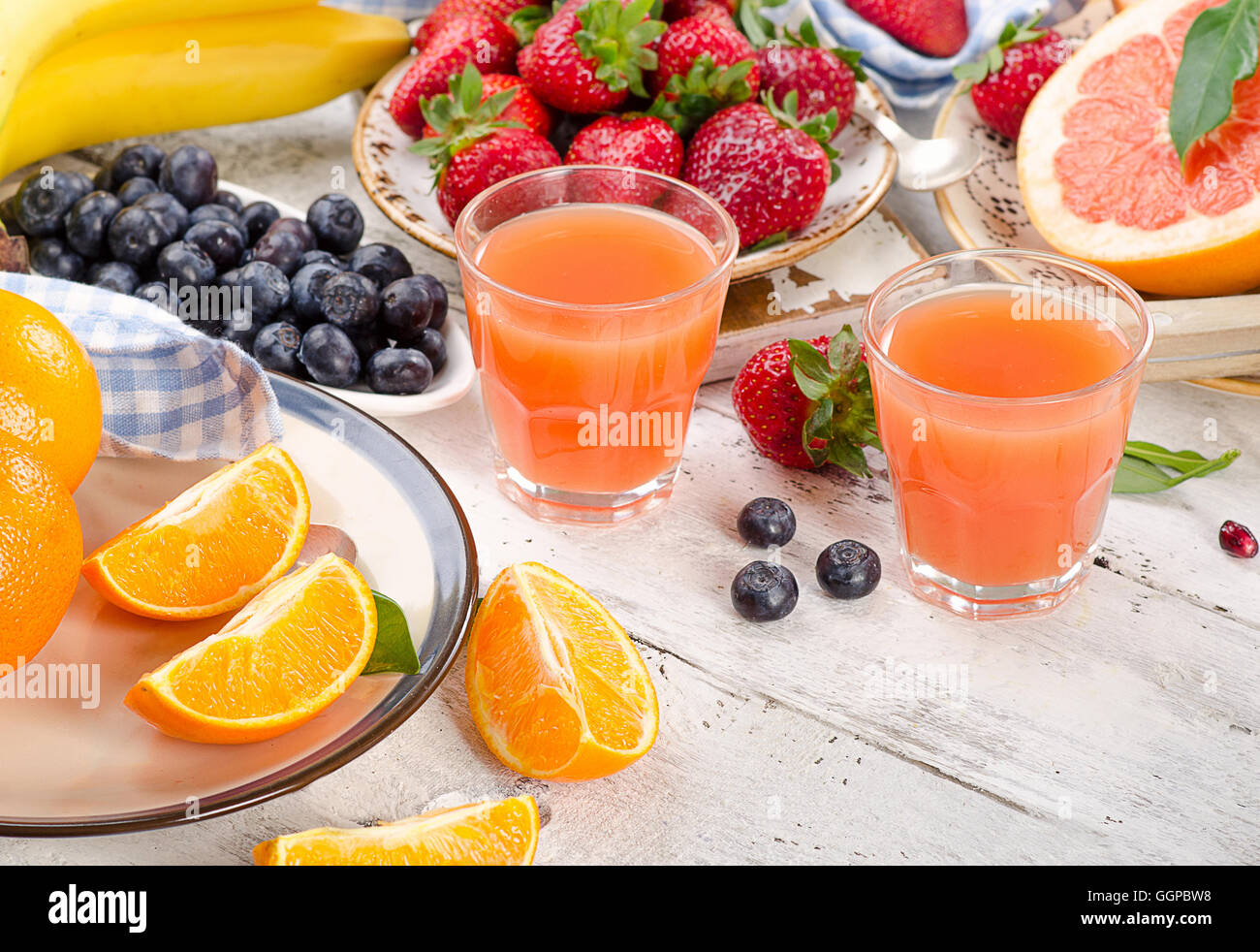 Citrus juice, fruits and berries on wooden background. Healthy eating. Top view Stock Photo