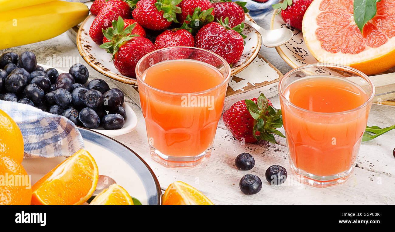 Citrus juice, fruits and berries on a wooden background. Healthy eating. Top view Stock Photo