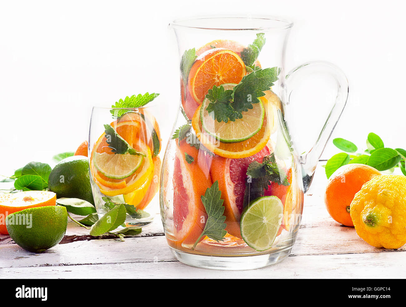 Pitcher and glass with citrus fruits and mint leaves. Stock Photo