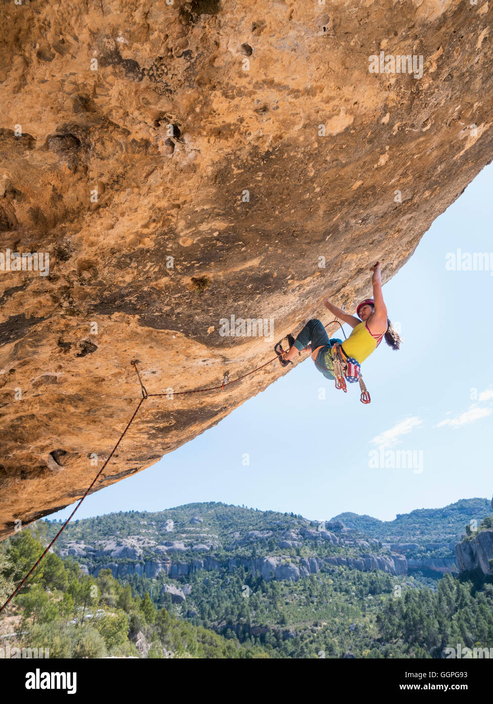 Mixed Race girl climbing rock Stock Photo