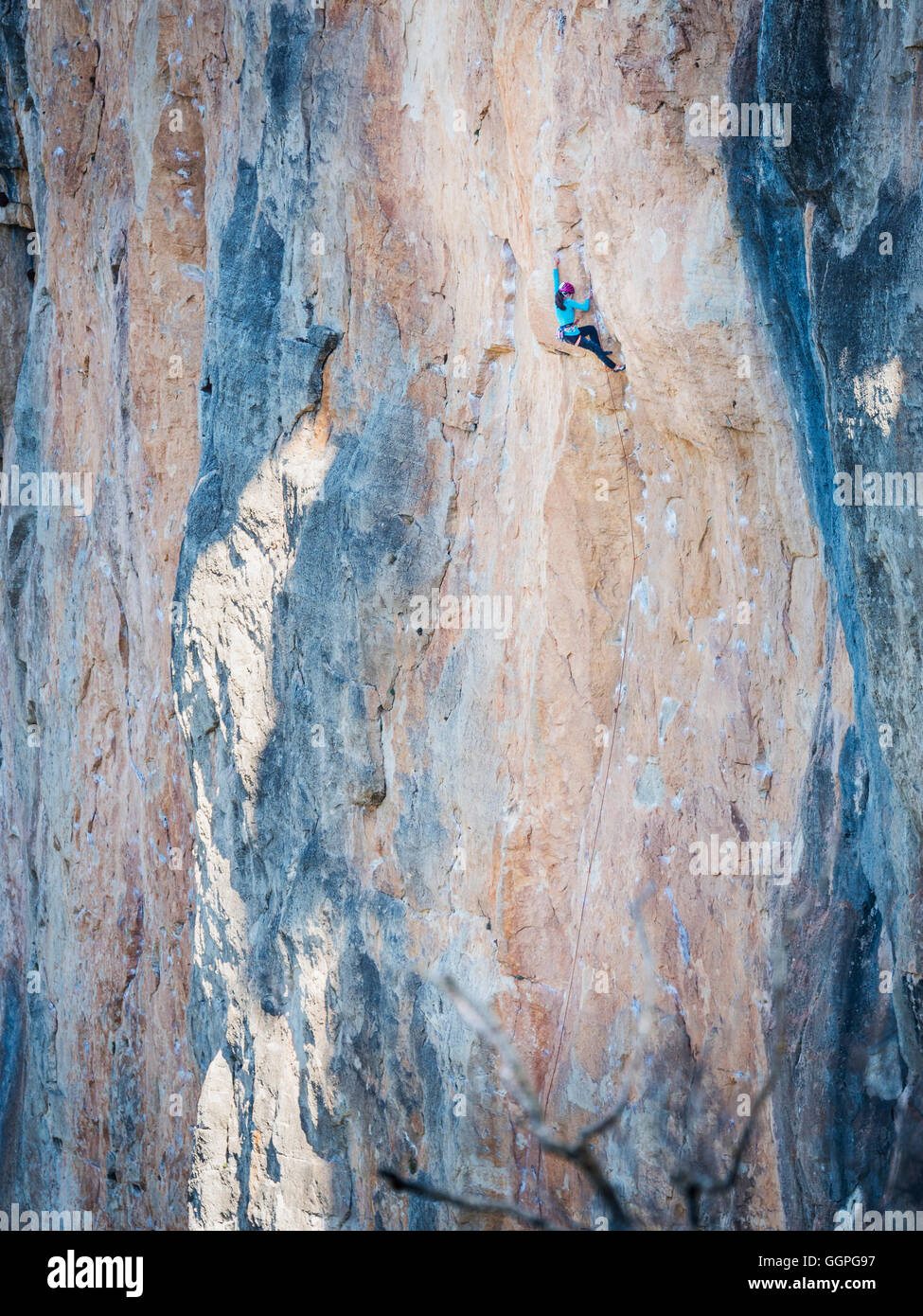 Mixed Race girl climbing rock Stock Photo