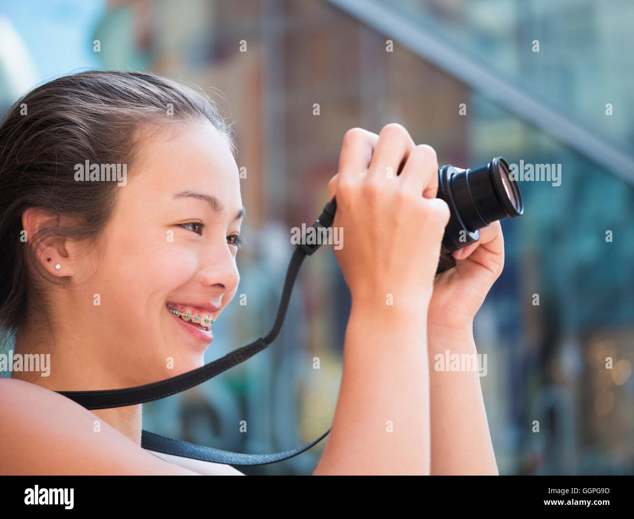Mixed Race girl photographing outdoors with digital camera Stock Photo