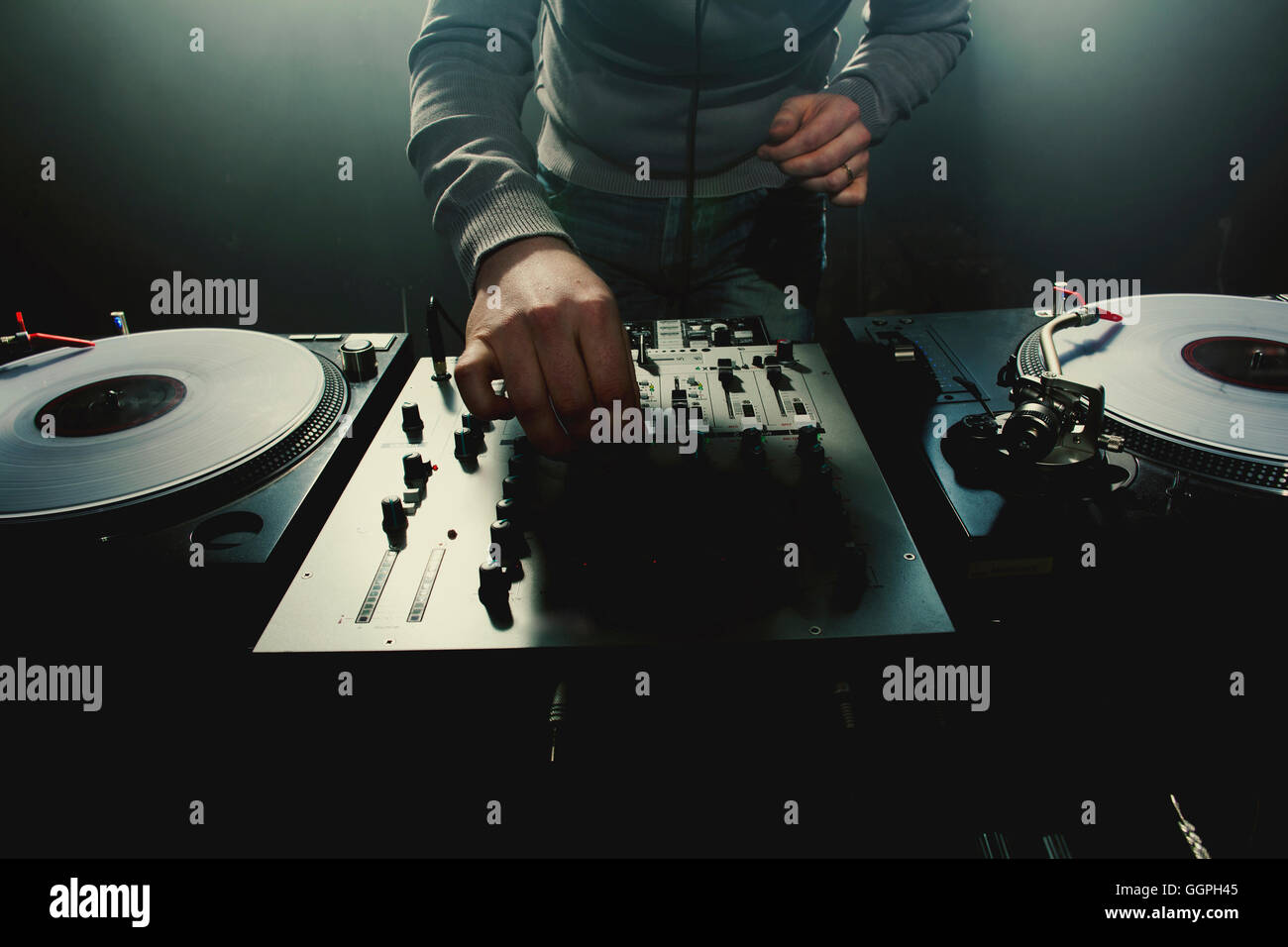 Caucasian disc jockey playing music in nightclub Stock Photo