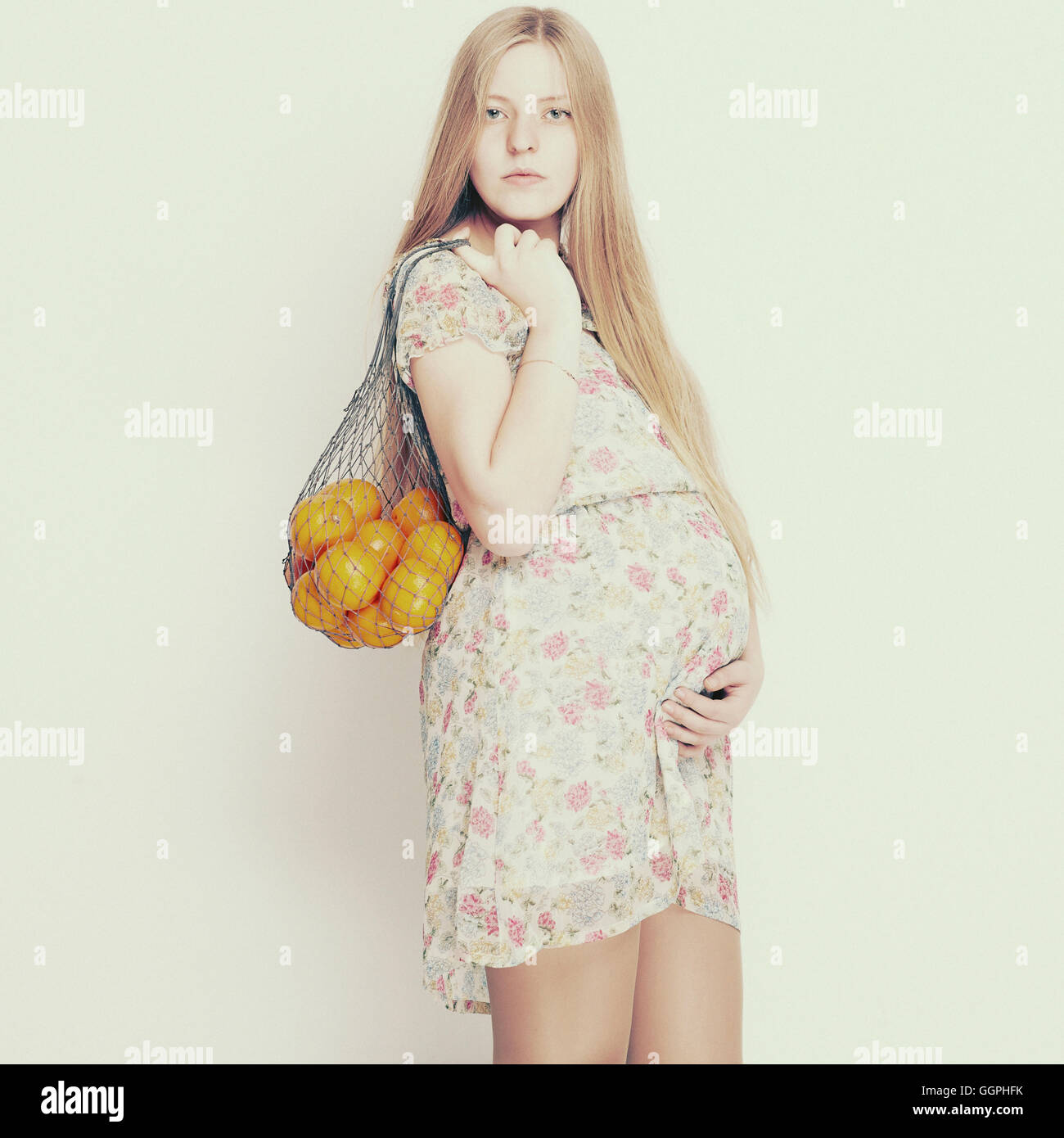 Pregnant woman carrying bag of fruit Stock Photo