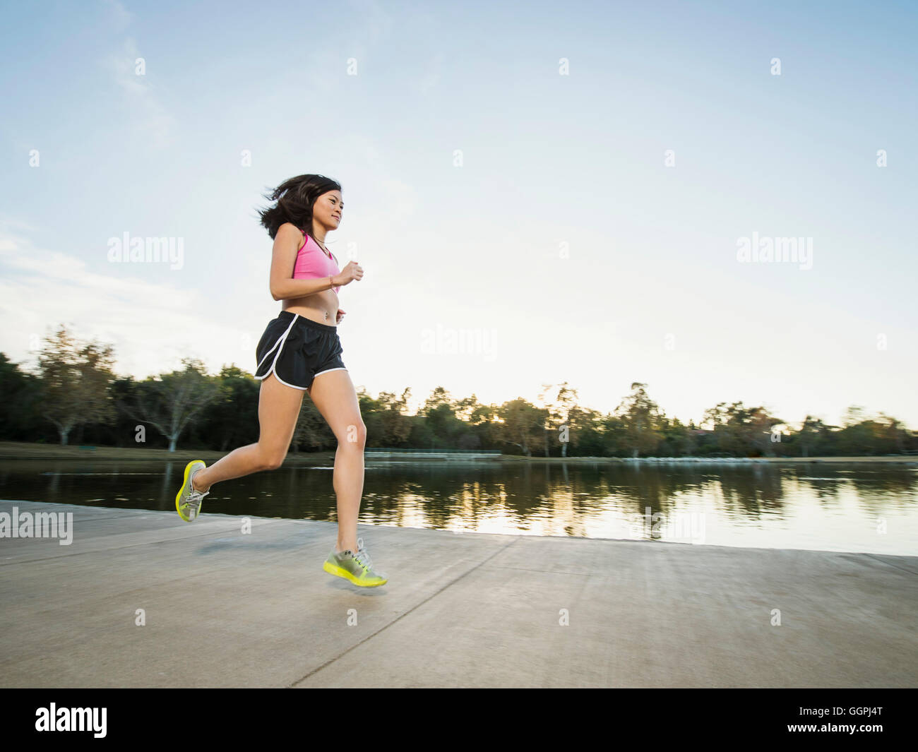 Chinese woman jogging in park Stock Photo