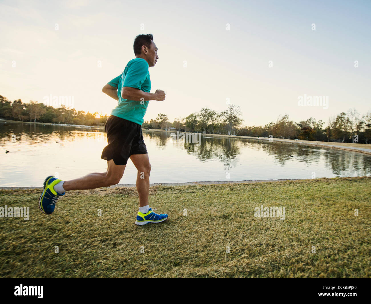 Older Chinese man running in park Stock Photo