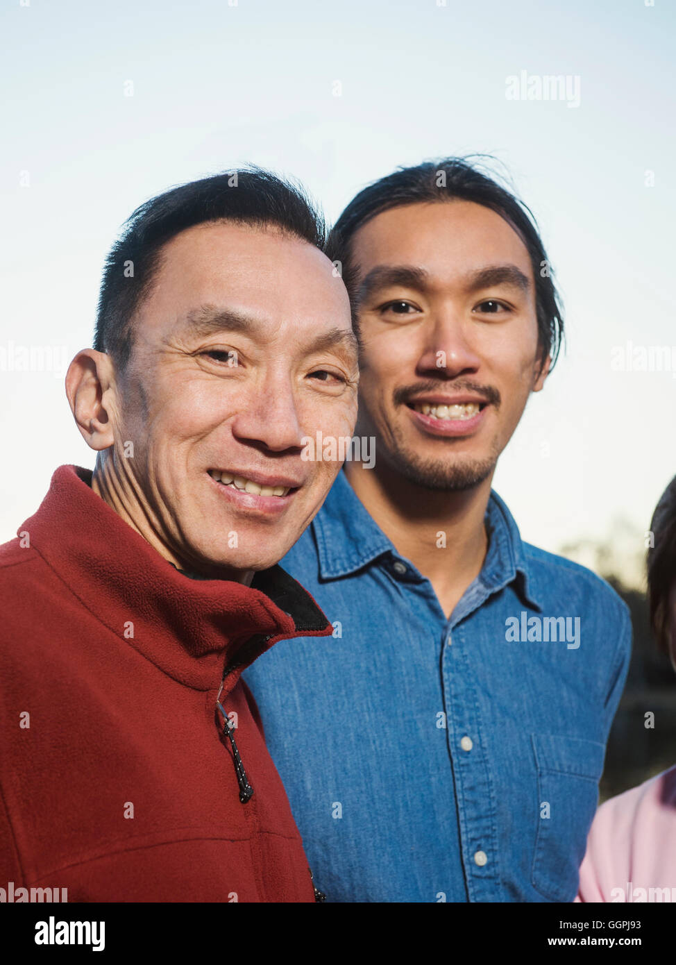 Chinese father and son smiling outdoors Stock Photo
